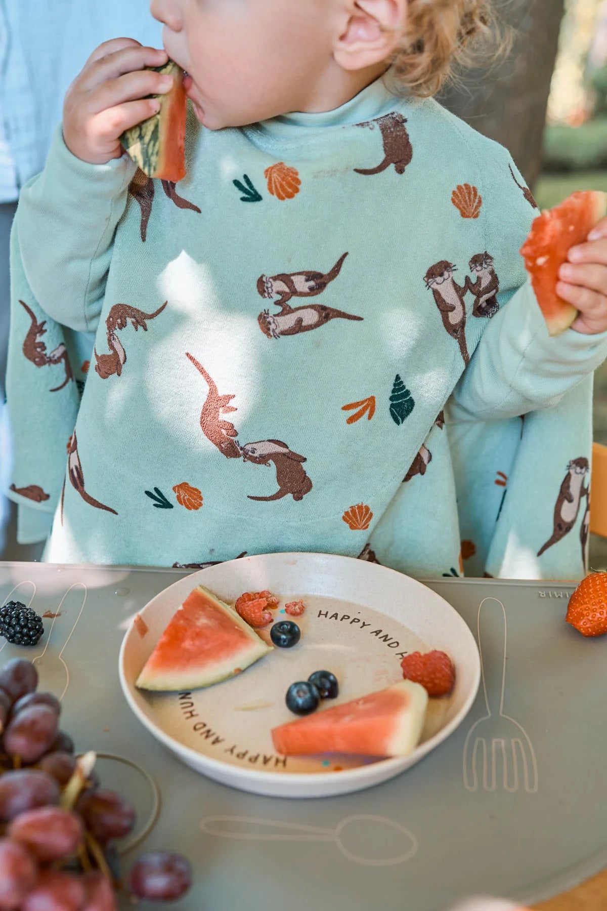 Baby trägt das wasserdichte Little Casimir Boo Lätzchen mit Otter-Motiv beim Essen – Bärechind Winterthur, Schweiz