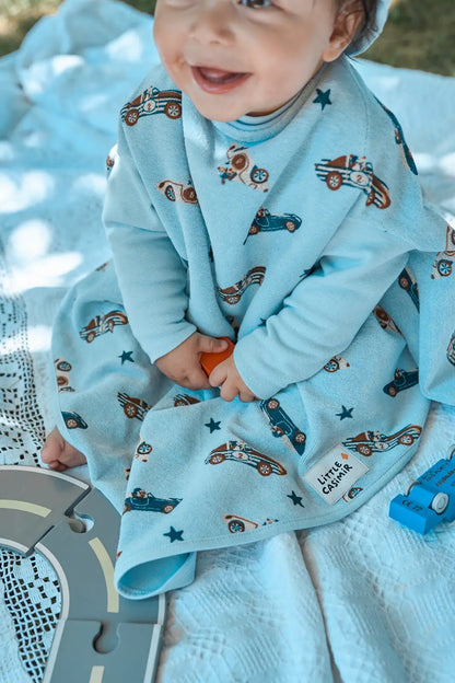 Kind trägt das wasserdichte Little Casimir Lätzchen Boo Sky Racers mit Ärmeln beim Spielen und Essen, erhältlich im Bärechind Winterthur