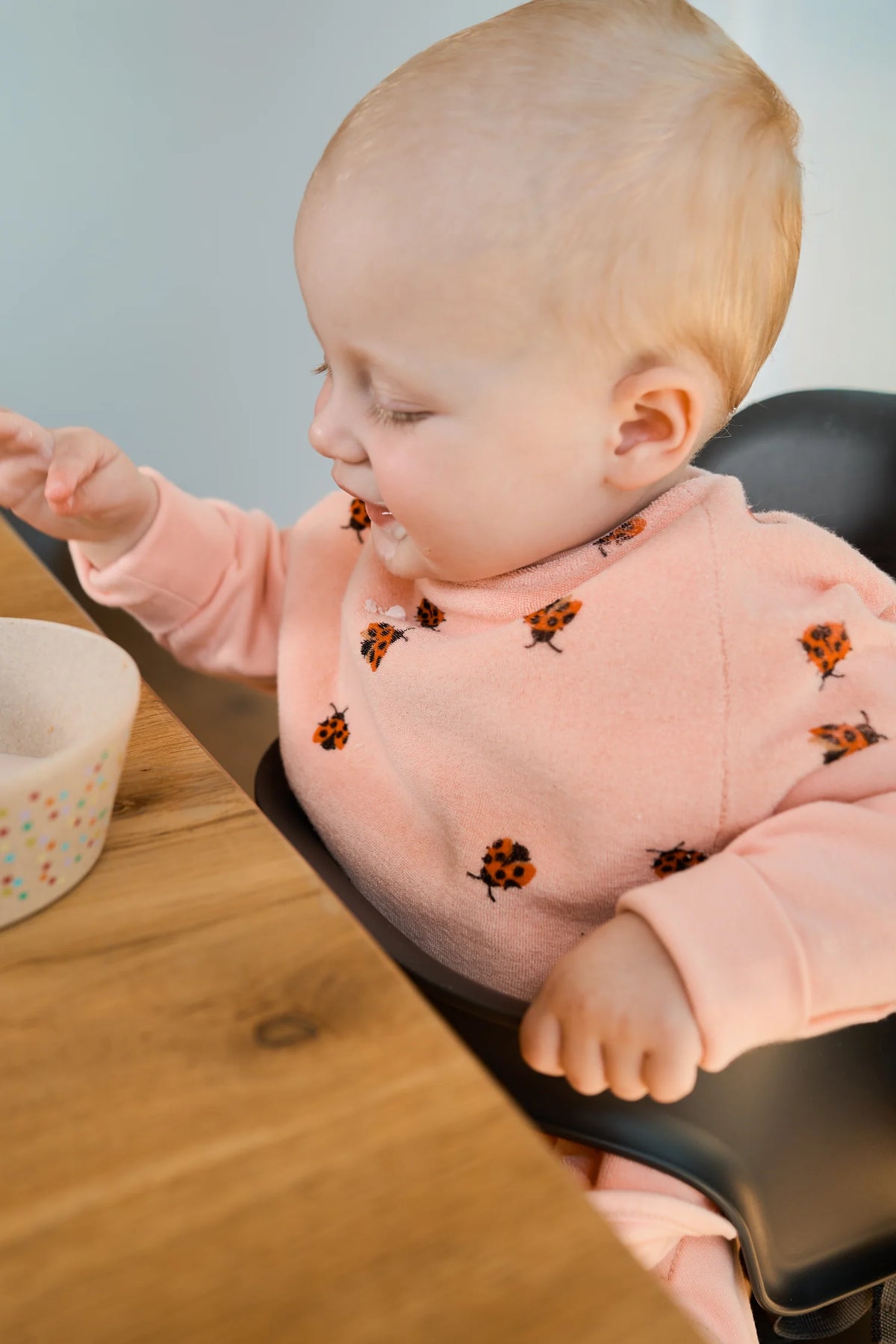 Baby trägt das wasserdichte Boo Lätzchen Love Bugs von Little Casimir beim Essen – Bärechind Winterthur, Schweiz