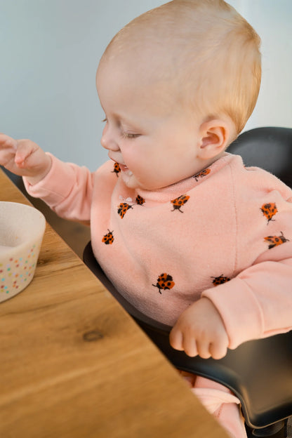 Baby trägt das wasserdichte Boo Lätzchen Love Bugs von Little Casimir beim Essen – Bärechind Winterthur, Schweiz