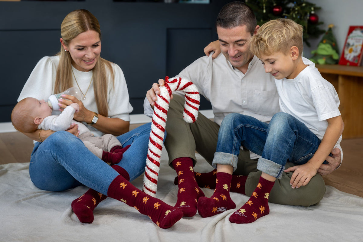 Familie trägt passende Weihnachtssocken mit Lebkuchenmann im gemeinsamen Look