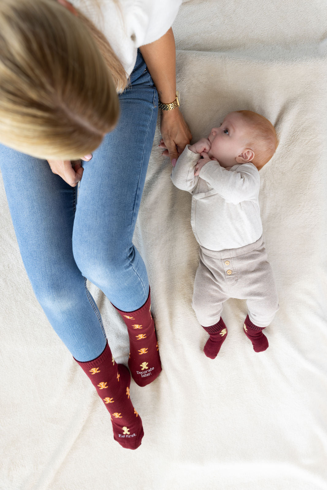 Socken mit Lebkuchenmann an Mama und Babyfüssen, von oben fotografiert