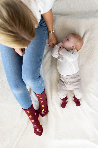 Socken mit Lebkuchenmann an Mama und Babyfüssen, von oben fotografiert