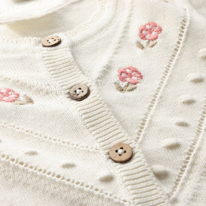 Detailaufnahme Stickerei und Knöpfe der Minymo Strickjacke aus Bio-Baumwolle im Bärechind Winterthur, Zürich, Schweiz