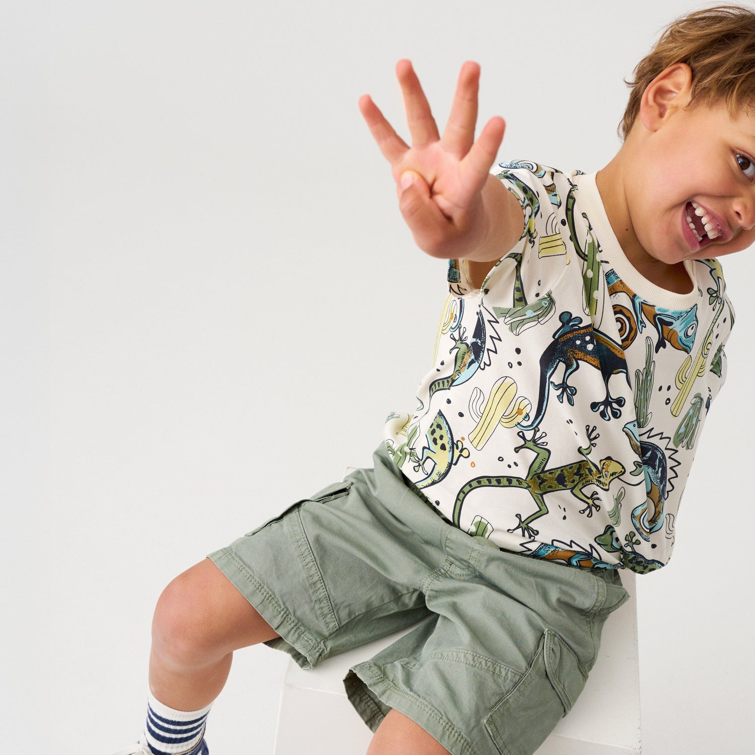 Kind trägt Minymo T-Shirt mit Reptilien Print, nachhaltige Kindermode im Bärechind Winterthur Zürich Schweiz.