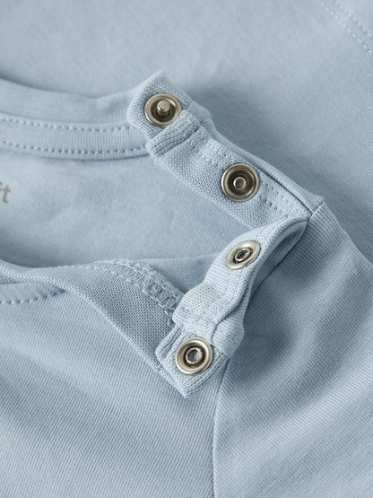 Detailaufnahme der Schulterdruckknöpfe am hellblauen Name It Kinder T-Shirt mit Löwenmotiv im Bärechind Winterthur