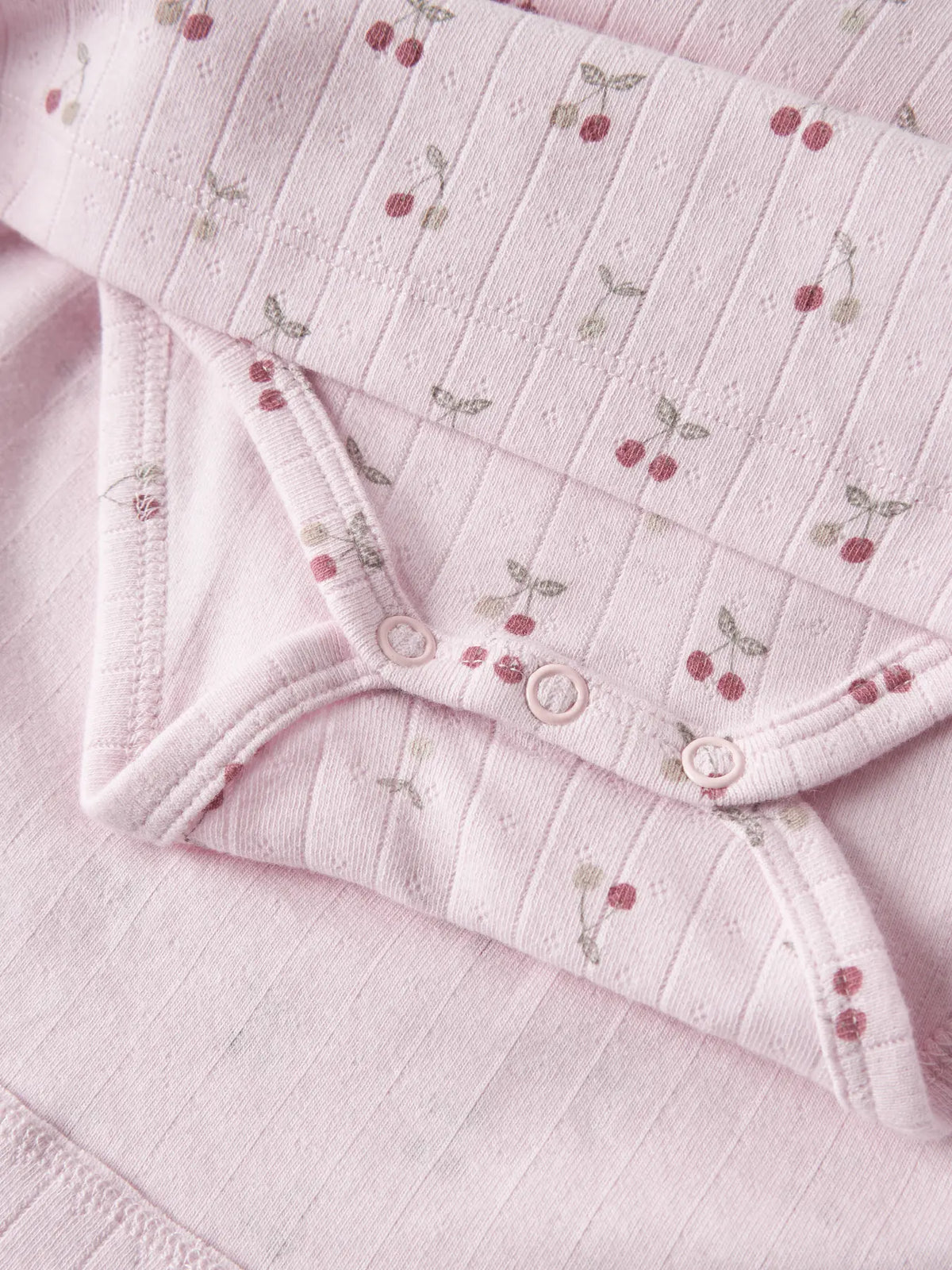 Detail Kirsch Print und Druckknöpfe am NAME IT Kleid Body aus Baumwolle zu kaufen im Bärechind Winterthur Zürich Schweiz.