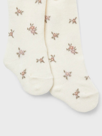 Diese hübsche Babystrumpfhose mit floralen Details von Name it ist in Winterthur bei Bärechind erhältlich. Hier sieht man die Strumpfhose seitlich ausgerollt.
