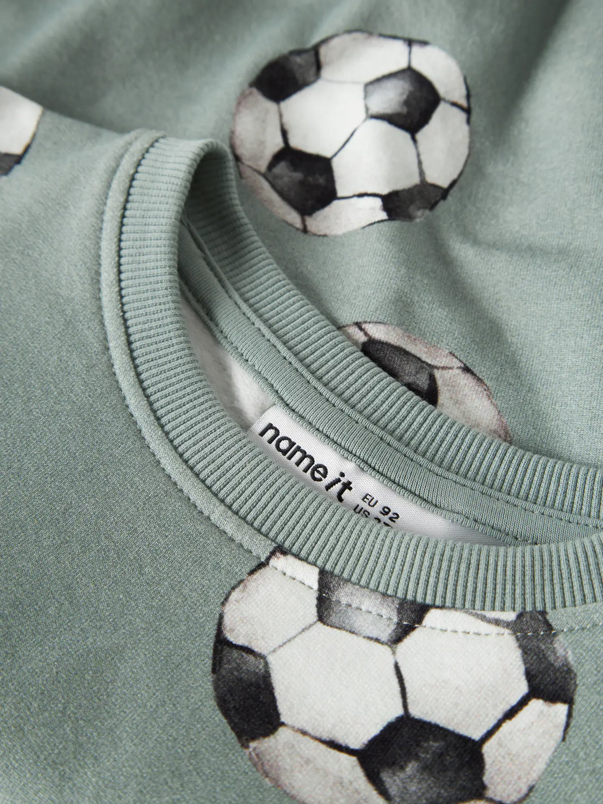 Detailaufnahme des Fussballprints auf dem NAME IT Sweatshirt in Desert Sage, erhältlich im Bärechind.