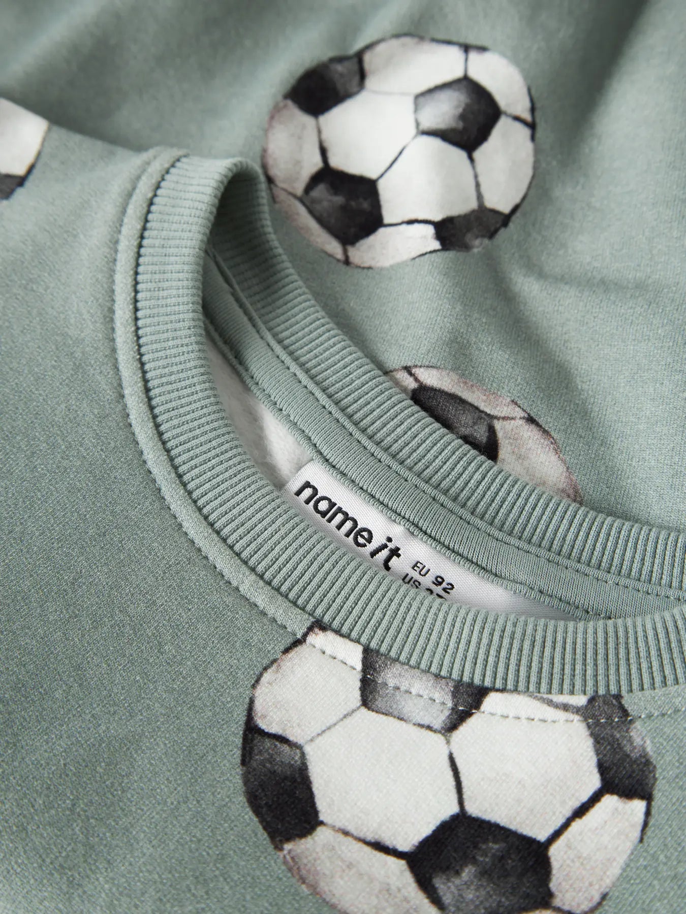 Detailaufnahme des Fussballprints auf dem NAME IT Sweatshirt in Desert Sage, erhältlich im Bärechind.