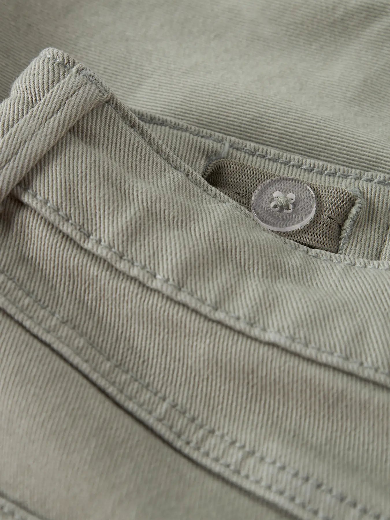 Detailaufnahme von grünen Chino Shorts mit Knopf von name it bei Bärechind in Winterthur, Zürich, Schweiz