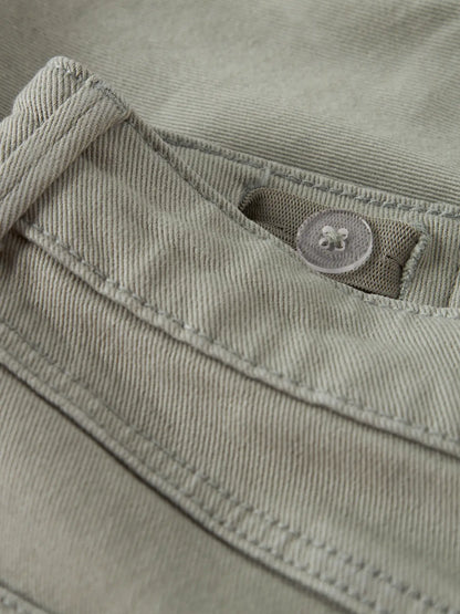 Detailaufnahme von grünen Chino Shorts mit Knopf von name it bei Bärechind in Winterthur, Zürich, Schweiz