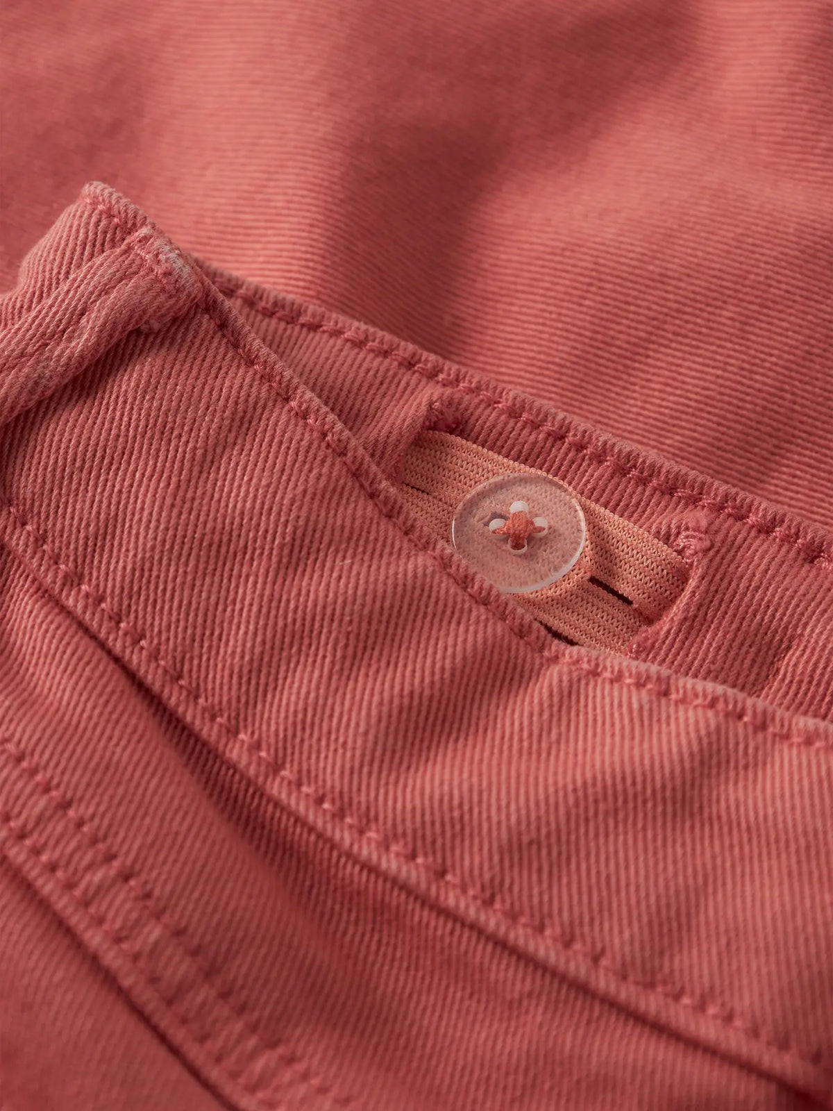 Detailaufnahme von Chino Shorts Stoff mit Knopf in Koralle von name it bei Bärechind in Winterthur, Zürich, Schweiz