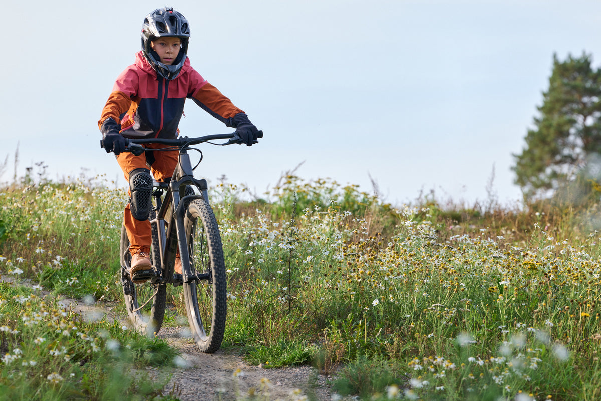 Kind beim Velofahren mit den Reima Tehden Softshell Handschuhen in Black