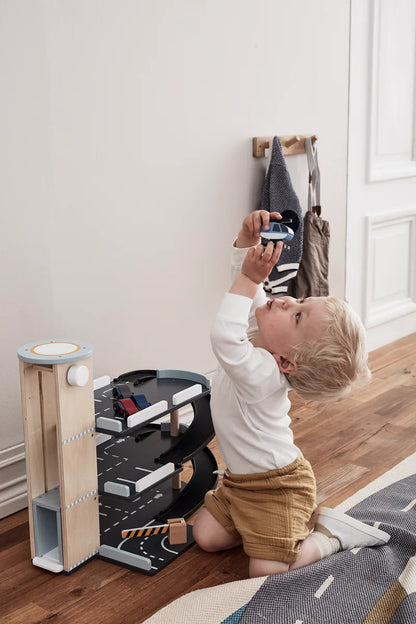 Kind spielt mit der Spielzeug Parkgarage AIDEN aus Holz von Kids Concept, zu kaufen bei Bärechind in Winterthur, Zürich, Schweiz.