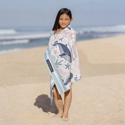 Kind am Strand mit dem leichten und schnelltrocknenden Woods & Waves Strandtuch Sea of Dreams